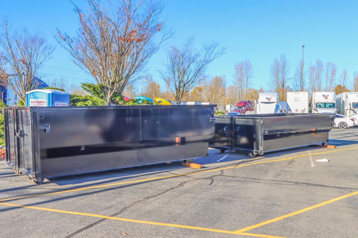 Professional dumpster rental service with roll-off container on residential driveway in Spring Lake